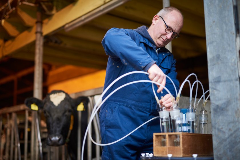 Onderzoeker Hendrik Jan van Dooren sluit de flesjes aan waarmee ammoniak gemeten wordt  